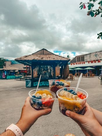 Three acai bowls cheersing from elsie smoothie bowl at the polynesian cultural center on oahu