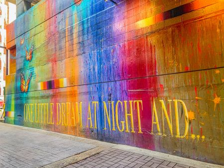 colorful mural with patches of different colors and text that reads one little dream at night and...