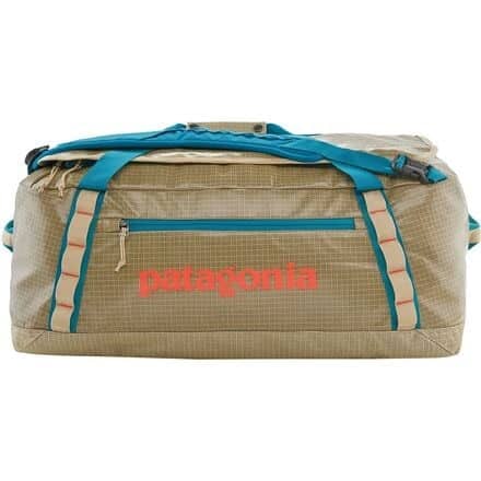Beige duffel bag with patagonia written in orange and blue accents on the straps