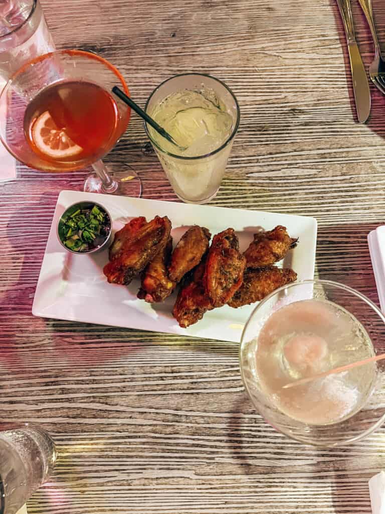 Table with chicken wings and cocktails