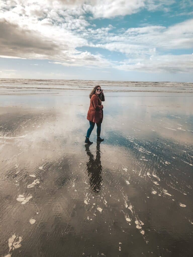 girl on the beach in ocean shores Washington wearing a red sweater and jeans
