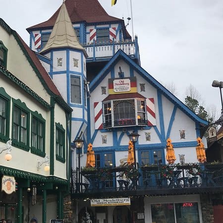 A quaint and colorful building in Helen, Georgia, designed in a charming Bavarian style, complete with festive decorations and flags, evoking the feel of a traditional German village
