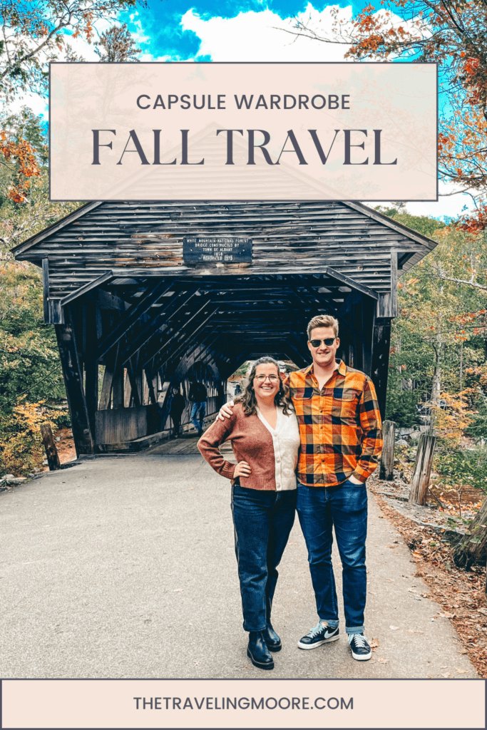 A promotional image for a fall travel capsule wardrobe with a couple in seasonal attire standing in front of a historic covered bridge. The image features a text overlay that reads 'CAPSULE WARDROBE FALL TRAVEL' at the top, and the website 'THETRAVELINGMOORE.COM' at the bottom, set against a backdrop of autumn leaves and a clear sky.