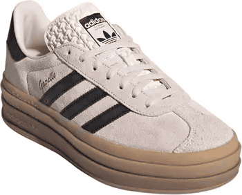 Adidas Gazelle sneaker in beige with classic three stripes in navy, white laces, and signature trefoil logo on the tongue