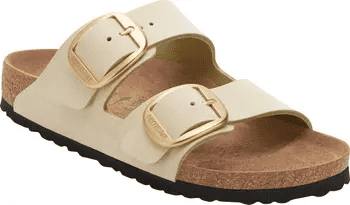 Beige Birkenstock sandals with dual gold-tone buckles and cork footbed on a black sole