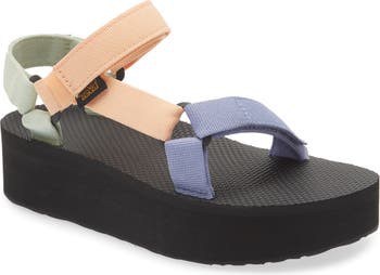 Platform Teva sandals featuring a chunky black sole with pastel straps in peach, green, and lavender.