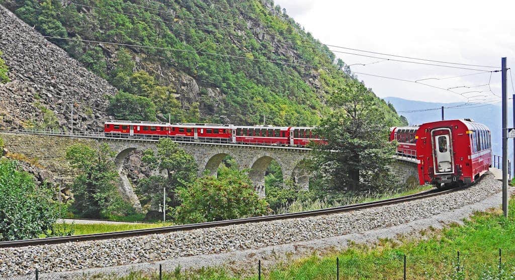 Red Train on Black Steel Train Rail during Day